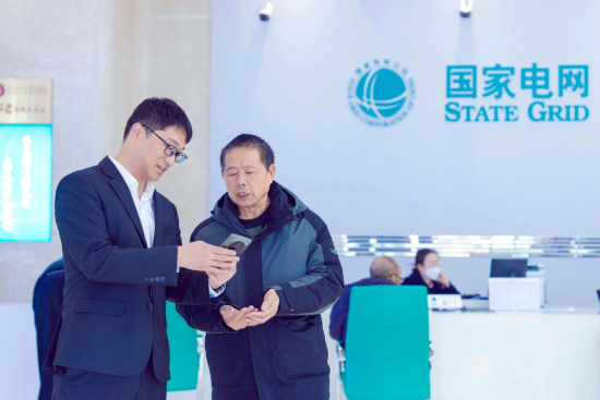 图为赵自威向客户介绍线上办理用电方法。况敏 摄 图为赵自威向客户介绍线上办理用电方法。况敏 摄