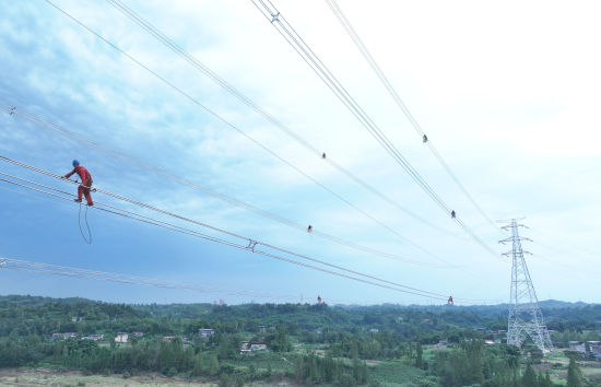 图为重庆送变电公司员工在“疆电入渝”配套工程500千伏渝岳线跨嘉陵江安装间隔棒。周亚 摄 图为重庆送变电公司员工在“疆电入渝”配套工程500千伏渝岳线跨嘉陵江安装间隔棒。周亚 摄