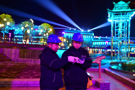 图为2月9日,国网重庆秀山供电公司洪安供电所员工在“不夜边城 秀山有戏”风情小镇记录安全用电检查情况。万雪莲 摄 图为2月9日,国网重庆秀山供电公司洪安供电所员工在“不夜边城 秀山有戏”风情小镇记录安全用电检查情况。万雪莲 摄