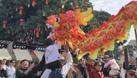 图为游客体验舞龙、摸龙头。铜梁区委宣传部 供图 图为游客体验舞龙、摸龙头。铜梁区委宣传部 供图