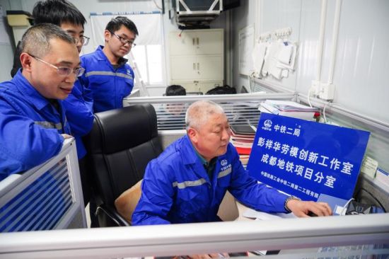 图为彭祥华(右)和同事在工作室研究工作。 图为彭祥华(右)和同事在工作室研究工作。