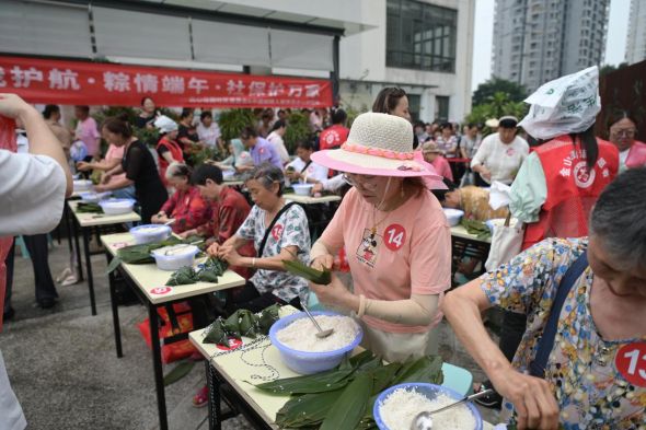图为民心佳园第九届包粽子比赛现场。陈鑫 摄 图为民心佳园第九届包粽子比赛现场。陈鑫 摄