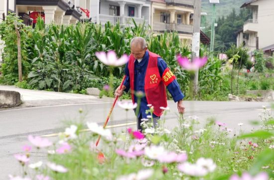 图为秦光天正在清扫街道。丰都县委宣传部供图 图为秦光天正在清扫街道。丰都县委宣传部供图
