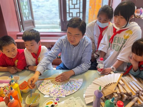 图为孩子们体验画折扇。 荣昌区委统战部供图 图为孩子们体验画折扇。 荣昌区委统战部供图