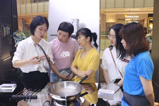图为TIKUU钛星球重庆店负责人为顾客讲解钛产品。 陈佳欣摄 图为TIKUU钛星球重庆店负责人为顾客讲解钛产品。 陈佳欣摄