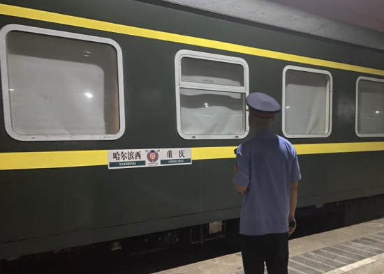 图为59岁的助理值班员杨现送别列车。 邱小雅 摄 图为59岁的助理值班员杨现送别列车。 邱小雅 摄