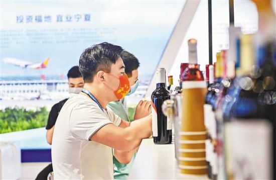 图为7月21日,西洽会现场宁夏展馆,嘉宾正在了解葡萄酒。 龙帆 摄 图为7月21日,西洽会现场宁夏展馆,嘉宾正在了解葡萄酒。 龙帆 摄