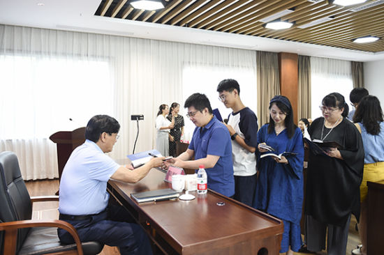 图为重庆市诗词学会会长凌泽欣现场签名赠书。 何蓬磊 摄 图为重庆市诗词学会会长凌泽欣现场签名赠书。 何蓬磊 摄