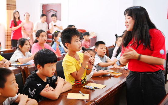 图为大学生与小朋友用普通话交流。潘霞文 摄 图为大学生与小朋友用普通话交流。潘霞文 摄