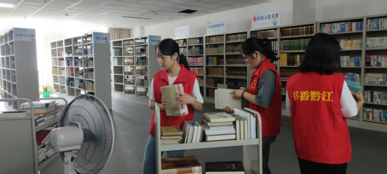 图为志愿者们正在对图书进行分拣归档。黔江区委统战部供图