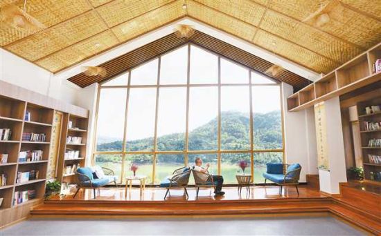 7月29日,桥头镇桥头村,一游客悠闲地在村民服务中心里的读书屋看书。 7月29日,桥头镇桥头村,一游客悠闲地在村民服务中心里的读书屋看书。