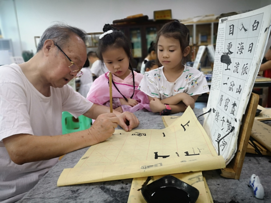 图为民建书法家会员开展免费书法培训。 冉妮 摄 图为民建书法家会员开展免费书法培训。 冉妮 摄