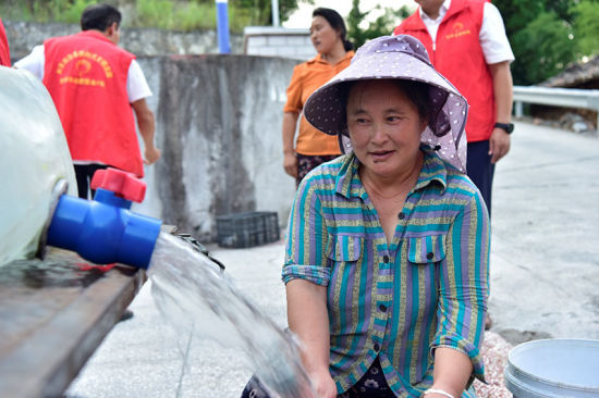 图为当地村民到临时设置的集中送水点取水。前来排队取水的一位村民说,每次都要把家里能用的盛水工具灌满,以确保全家人至少2天的生活用水。彭国威 摄 图为当地村民到临时设置的集中送水点取水。前来排队取水的一位村民说,每次都要把家里能用的盛水工具灌满,以确保全家人至少2天的生活用水。彭国威 摄