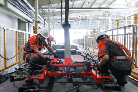 车辆检修车间均衡修班组员工王磊(左),刘超正在进行420车车顶受电弓