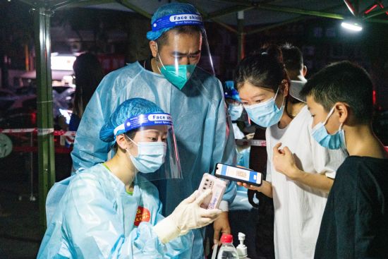 东湖南路社区农贸市场采样点,扫码后,队员再次与居民核实相关信息。张霁雯 摄 东湖南路社区农贸市场采样点,扫码后,队员再次与居民核实相关信息。张霁雯 摄