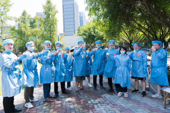 星光社区公园采样点,年轻的队员们在休息轮换时端起了消暑的绿豆汤。黄维正 摄 星光社区公园采样点,年轻的队员们在休息轮换时端起了消暑的绿豆汤。黄维正 摄