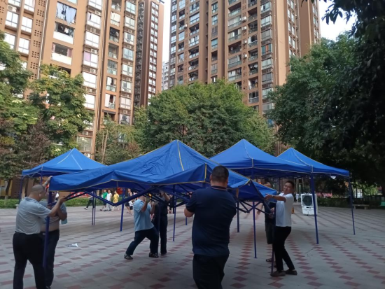 图为碧桂园的物业工作人员正在搭帐篷。碧桂园供图 图为碧桂园的物业工作人员正在搭帐篷。碧桂园供图