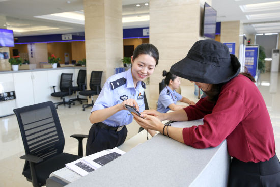 图为指引申请人办理出入境证件。 受访者供图 图为指引申请人办理出入境证件。 受访者供图