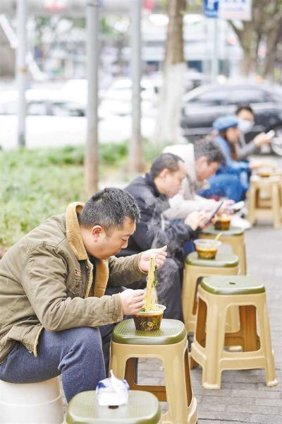 十二月二日,南岸区铜元局长江村一小面馆,市民在路边吃面。 特约摄影 郭旭/视觉重庆 十二月二日,南岸区铜元局长江村一小面馆,市民在路边吃面。 特约摄影 郭旭/视觉重庆