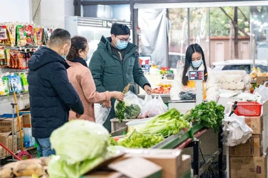 图为市民们拿着选购好的蔬菜排队称重。张霁雯 摄 图为市民们拿着选购好的蔬菜排队称重。张霁雯 摄