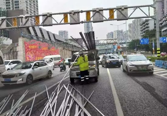 骁骑队员协助驾驶员搬运散落的钢条。 九龙坡区公安分局供图 骁骑队员协助驾驶员搬运散落的钢条。 九龙坡区公安分局供图