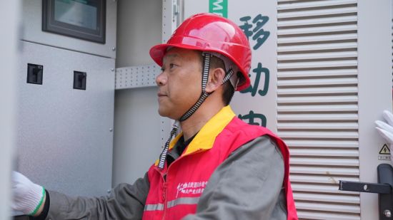图为石正川正在检查“移动电宝宝”。国网重庆电力供图 图为石正川正在检查“移动电宝宝”。国网重庆电力供图
