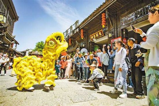 图①:4月30日,秀山县洪安古镇边城景区,游客们在观看舞狮表演。 胡程 摄 图①:4月30日,秀山县洪安古镇边城景区,游客们在观看舞狮表演。 胡程 摄