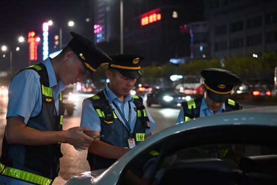 图为周仁洪(中)和同事正在进行夜间执法检查。张旭 摄 图为周仁洪(中)和同事正在进行夜间执法检查。张旭 摄
