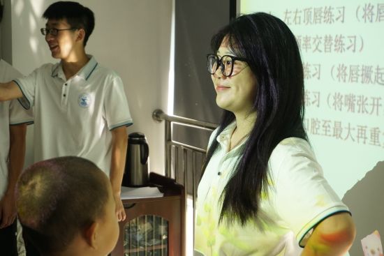 图为实践团成员刘静教孩子们发声练习。龙忆芸 摄 图为实践团成员刘静教孩子们发声练习。龙忆芸 摄