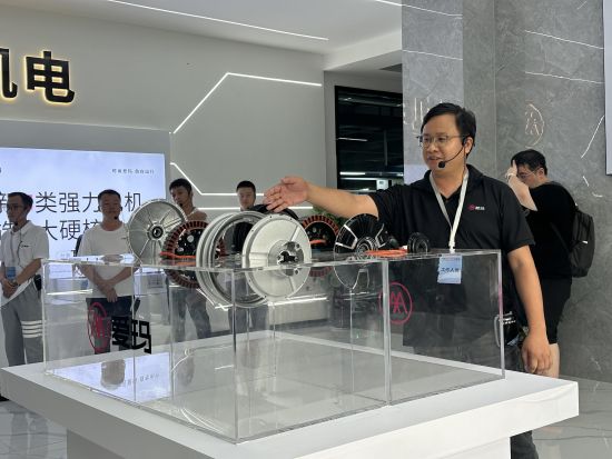图为工作人员向嘉宾们讲解爱玛自研电机。 景诗雁 摄 图为工作人员向嘉宾们讲解爱玛自研电机。 景诗雁 摄
