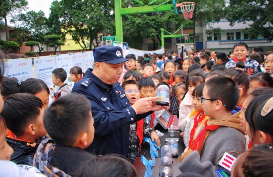 图为万盛禁毒办民警向同学们展示仿真毒品模型。刘亚兰摄 图为万盛禁毒办民警向同学们展示仿真毒品模型。刘亚兰摄