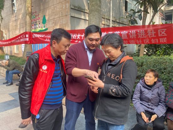图为巴南区中医院党员志愿者帮助龙德社区居民注册“渝快社区”小程序。 邹露 摄 图为巴南区中医院党员志愿者帮助龙德社区居民注册“渝快社区”小程序。 邹露 摄