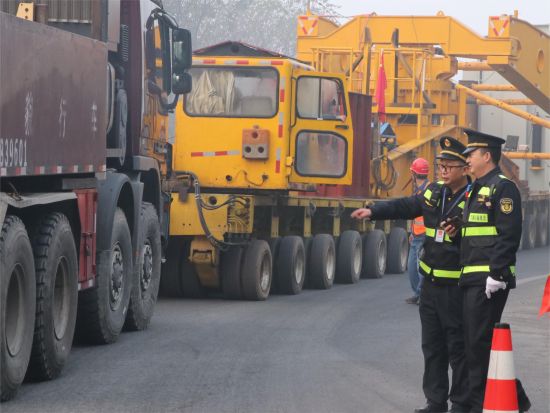 图为交通执法人员在现场护航设备运输。重庆交通执法部门供图 图为交通执法人员在现场护航设备运输。重庆交通执法部门供图
