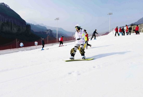 图为游客正正在滑雪。夏季餐饮等，散拆箱小吃摊位、可以或许大概称心没有开游客的滑雪培训、 王毅 摄