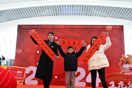 图为工作人员和写春联的旅客合影留念。重庆火车站供图 图为工作人员和写春联的旅客合影留念。重庆火车站供图