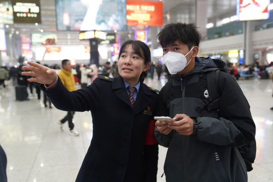图为工作人员为旅客指路。重庆火车站供图 图为工作人员为旅客指路。重庆火车站供图