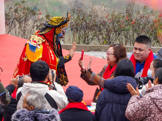 图为川剧变脸节目与村民互动。郭思云摄 图为川剧变脸节目与村民互动。郭思云摄