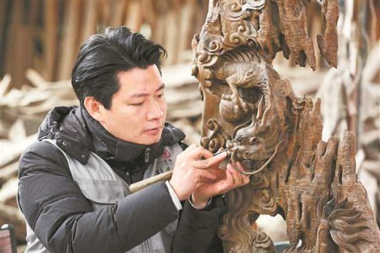 2月6日,巴南区石龙镇大兴村,巴南区非遗周氏木作代表性传承人周奎专心创作,他的木雕产品很受年轻人欢迎。通讯员 李攀 摄/视觉重庆 2月6日,巴南区石龙镇大兴村,巴南区非遗周氏木作代表性传承人周奎专心创作,他的木雕产品很受年轻人欢迎。通讯员 李攀 摄/视觉重庆