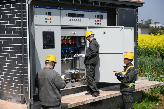 图为电力员工在景区对新增专用变压器配电房进行检查验收.