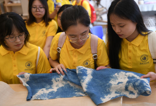图为织造好的成品夏布吸引大学生一探究竟。周毅 摄 图为织造好的成品夏布吸引大学生一探究竟。周毅 摄