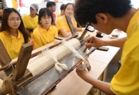 图为大学生体验织造夏布。周毅 摄 图为大学生体验织造夏布。周毅 摄
