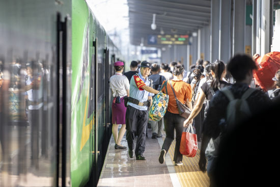 图为民警在站台引导旅客安全上下列车。胡勇 摄 图为民警在站台引导旅客安全上下列车。胡勇 摄
