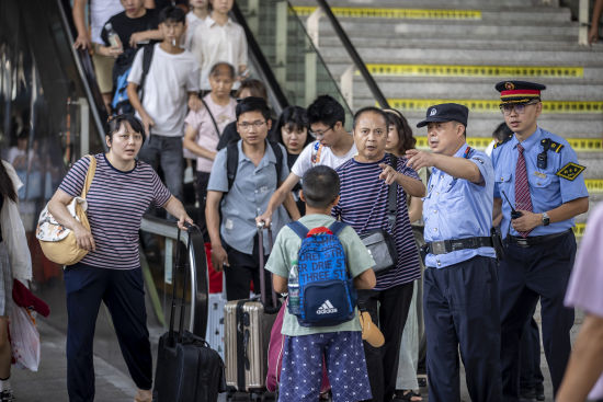 图为列车警长和列车长在站台引导旅客有序上车。胡勇 摄 图为列车警长和列车长在站台引导旅客有序上车。胡勇 摄