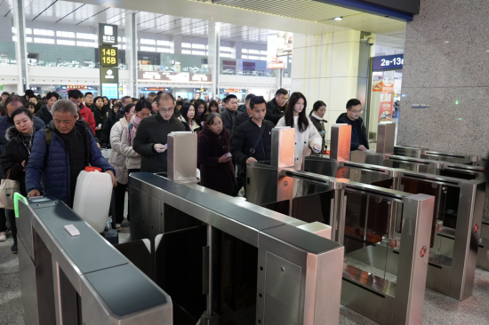 旅客们刷证检票乘车。汪亮 摄 旅客们刷证检票乘车。汪亮 摄