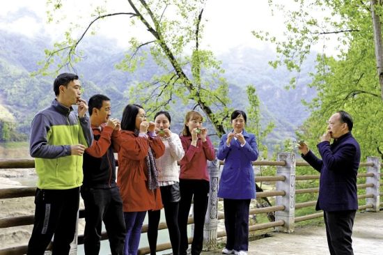 图为张麒麟(右)为石桥苗族土家族乡中心小学校的老师们现场传授木叶吹奏技艺 武隆区教委供图 图为张麒麟(右)为石桥苗族土家族乡中心小学校的老师们现场传授木叶吹奏技艺 武隆区教委供图