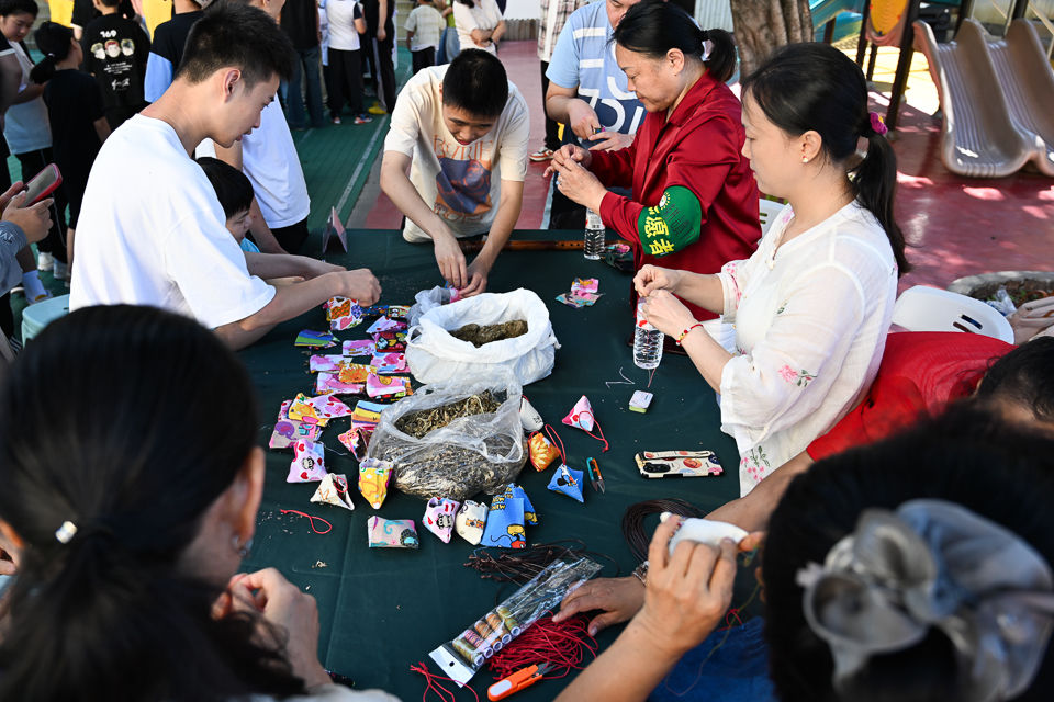图为特殊学校的师生与志愿者共同制作端午香囊。记者 何蓬磊 摄 图为特殊学校的师生与志愿者共同制作端午香囊。记者 何蓬磊 摄