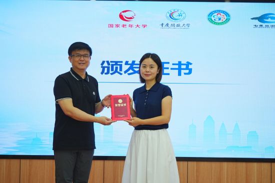 图为重庆开放大学终身教育处处长任杰为重庆医科大学附属第二医院副主任医师周宇颁发证书。国家老年大学重庆分部 供图 图为重庆开放大学终身教育处处长任杰为重庆医科大学附属第二医院副主任医师周宇颁发证书。国家老年大学重庆分部 供图
