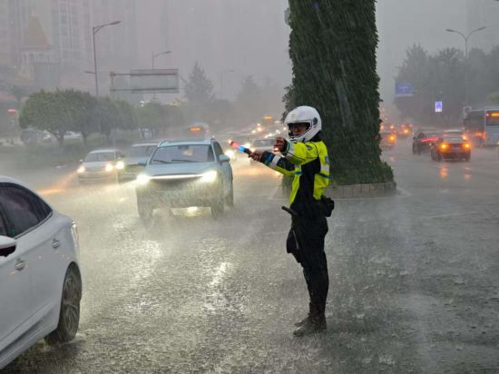 图为两江新区民警在暴雨中疏导交通。 两江新区公安局供图 图为两江新区民警在暴雨中疏导交通。 两江新区公安局供图