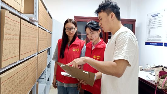 图为返家乡实践大学生向工作人员请教档案整理技巧 图为返家乡实践大学生向工作人员请教档案整理技巧