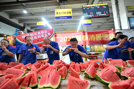图为工人们正在吃西瓜降暑。郭旭 摄 图为工人们正在吃西瓜降暑。郭旭 摄